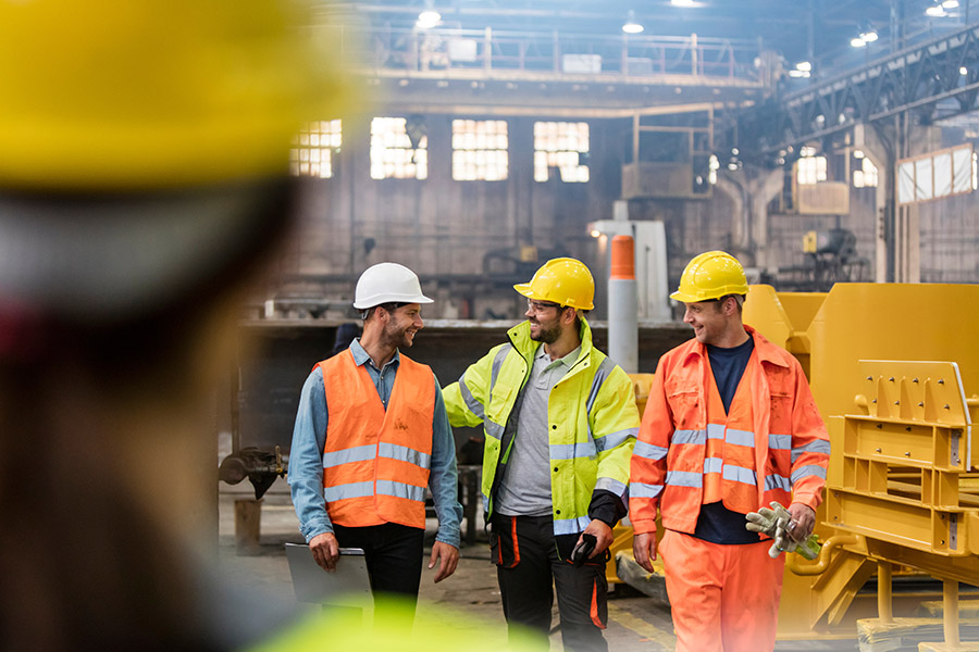 Steel workers walking and talking in factory